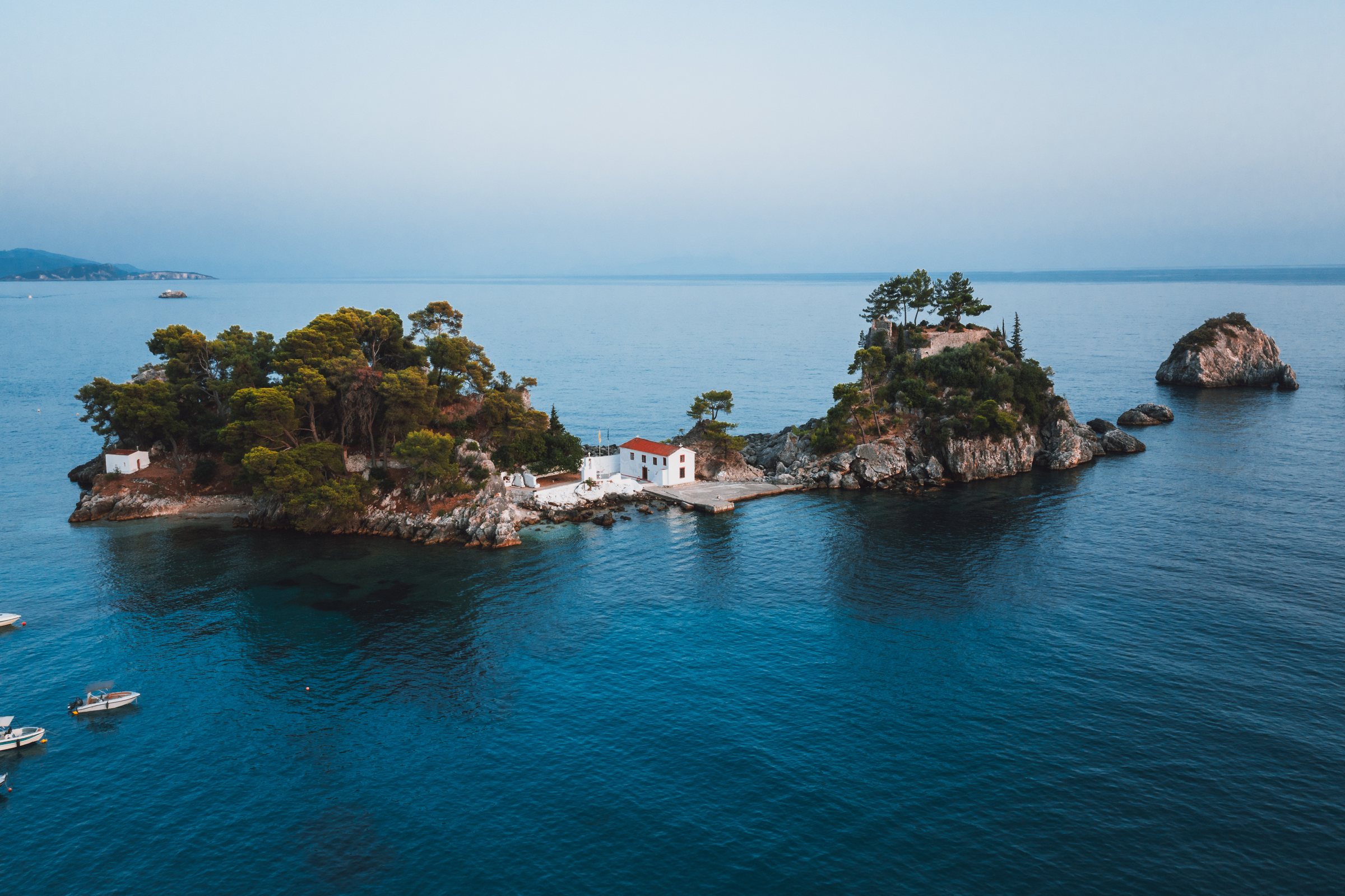 A tiny island church at dusk, the water gone soft and blue.