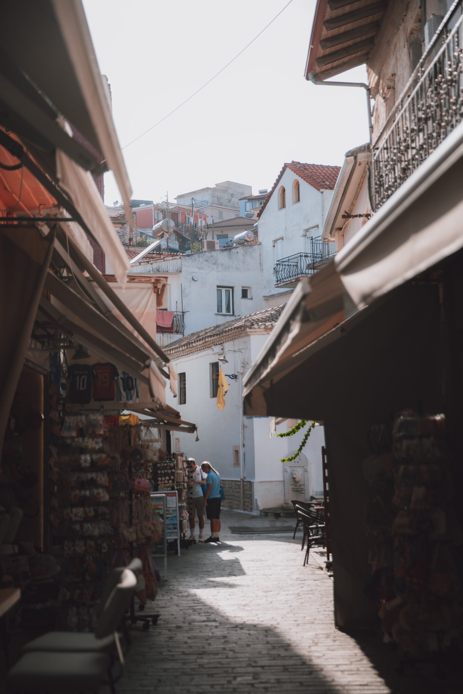 A narrow Parga alley with late light falling down the stone.