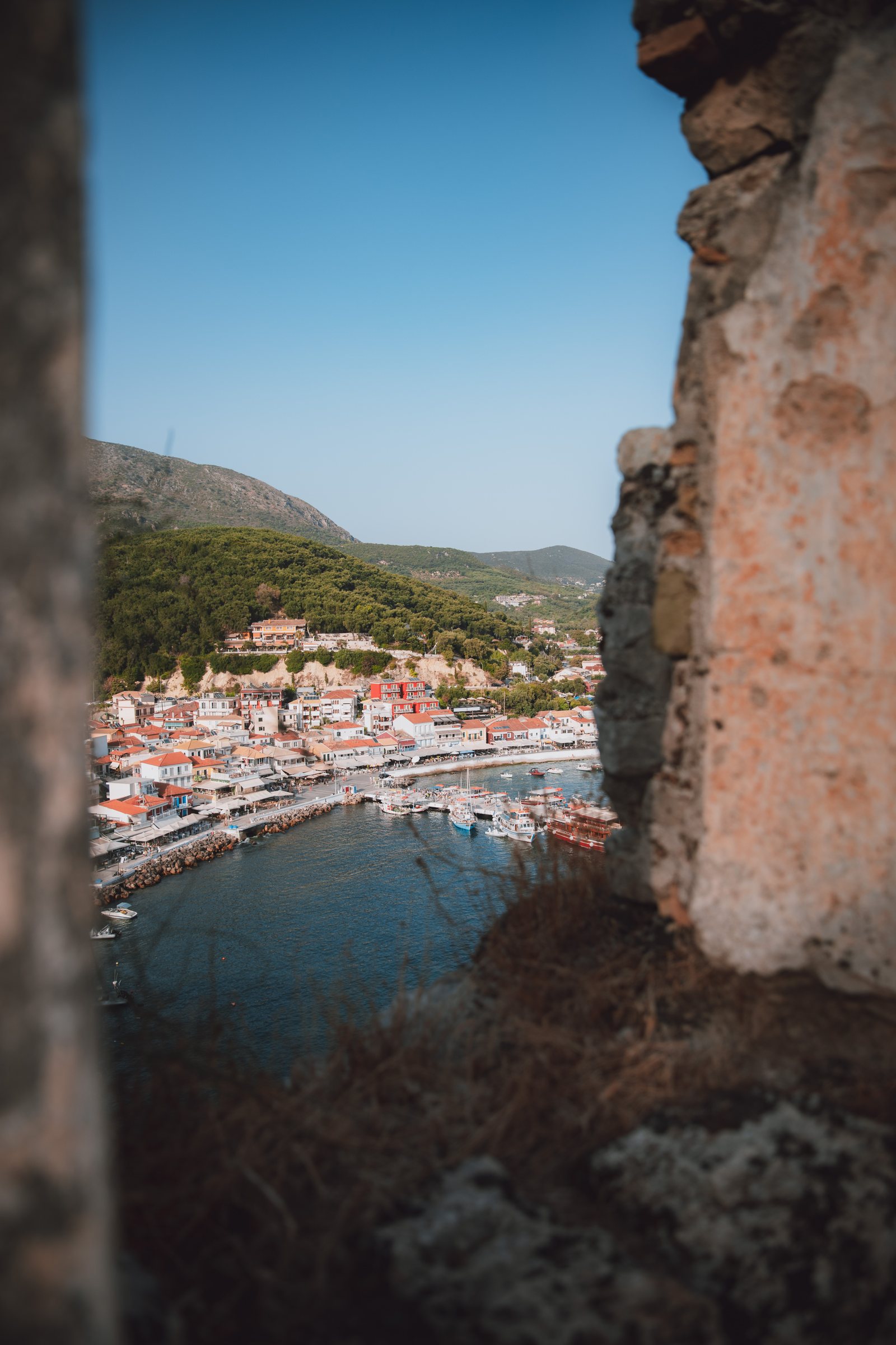 The town seen through a ruined stone window frame.