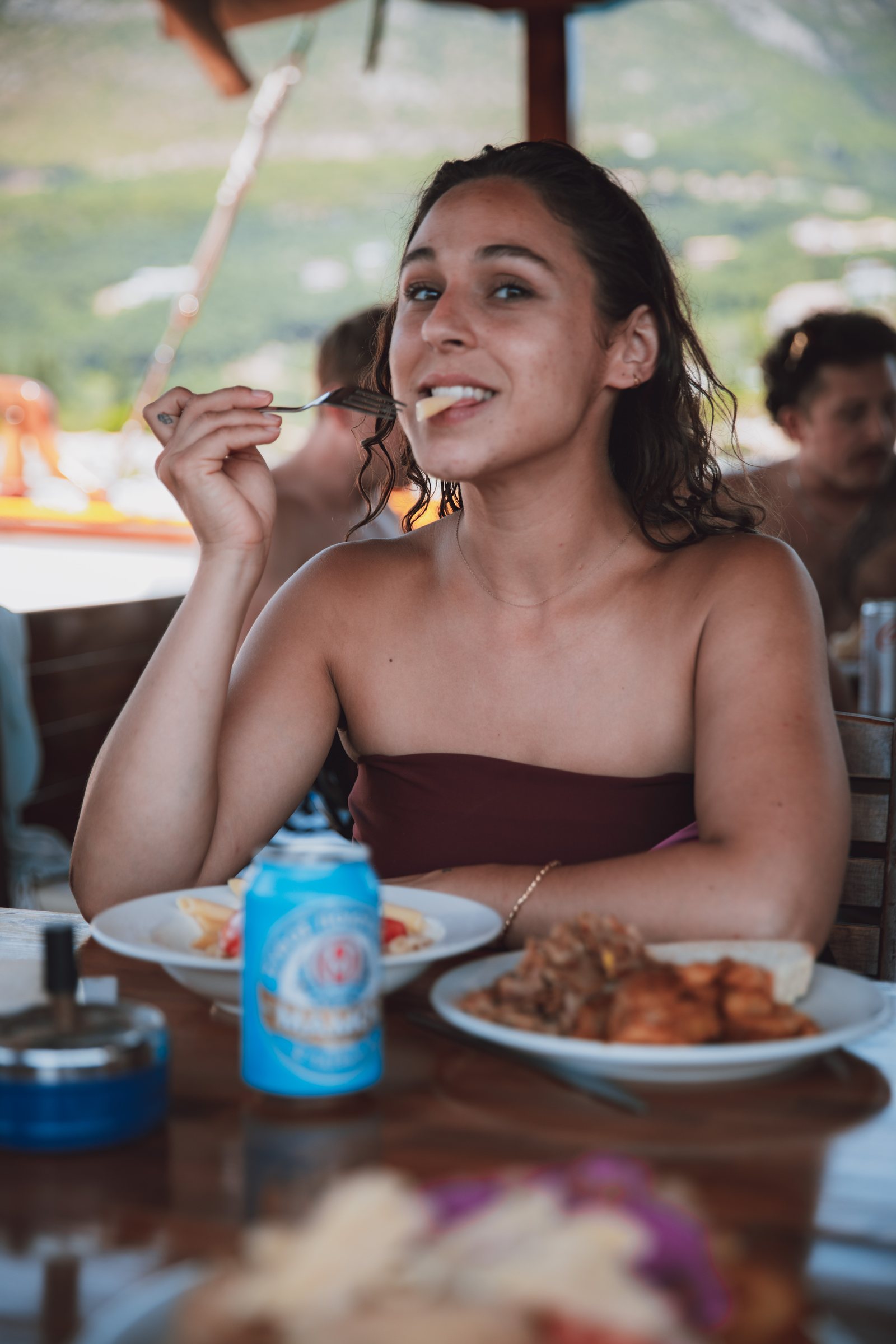 Laughing over dinner, foreground blurred, the table falling away behind.