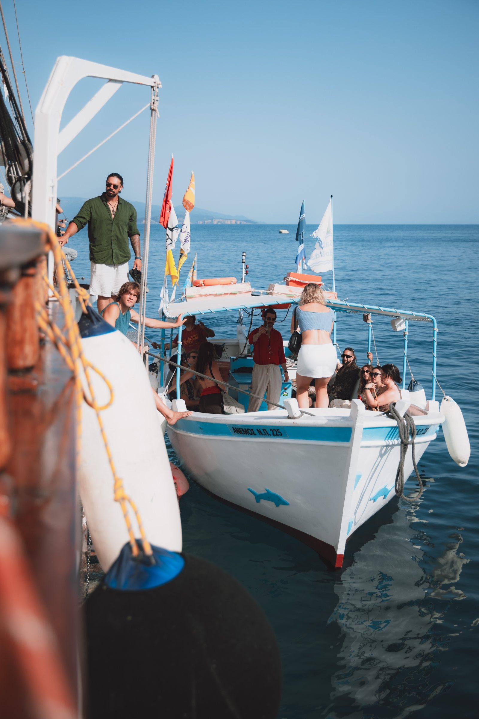 Guests boarding the tender alongside the gulet, ropes and fenders in the foreground.